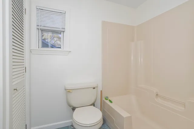 a white toilet sitting next to a bath tub