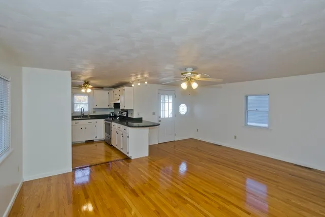a view of a kitchen with kitchen island wooden floor and stainless steel appliances