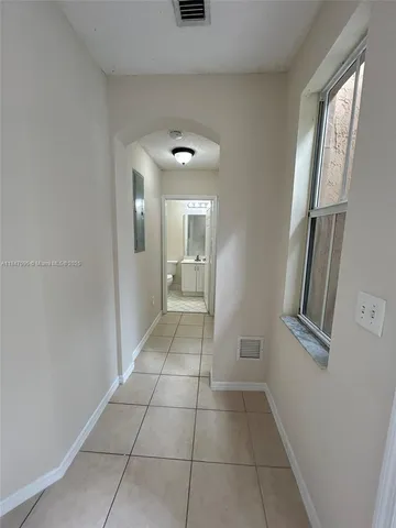 a view of a hallway to rooms and stairs