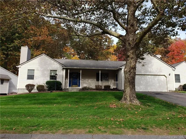a front view of a house with a yard and trees