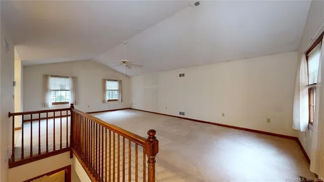 a view of an empty room with window and stairs