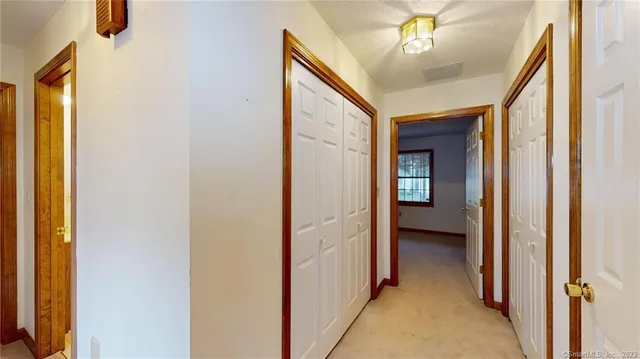 a view of a hallway with a chandelier and a livingroom