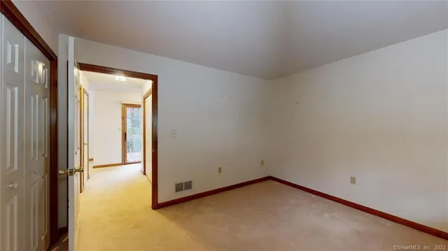 an empty room with windows and closet