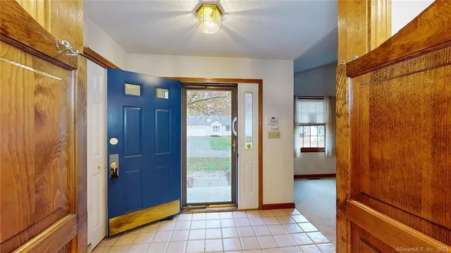 a view of a hallway with a dining room and chandelier door