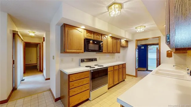 a kitchen with stainless steel appliances granite countertop wooden cabinets a stove top oven a sink and dishwasher