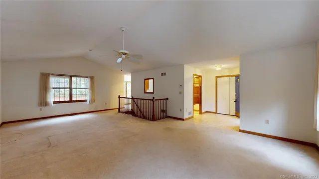 an empty room with windows and ceiling fan view
