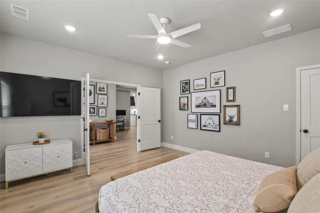 a spacious bedroom with a bed and a flat screen tv