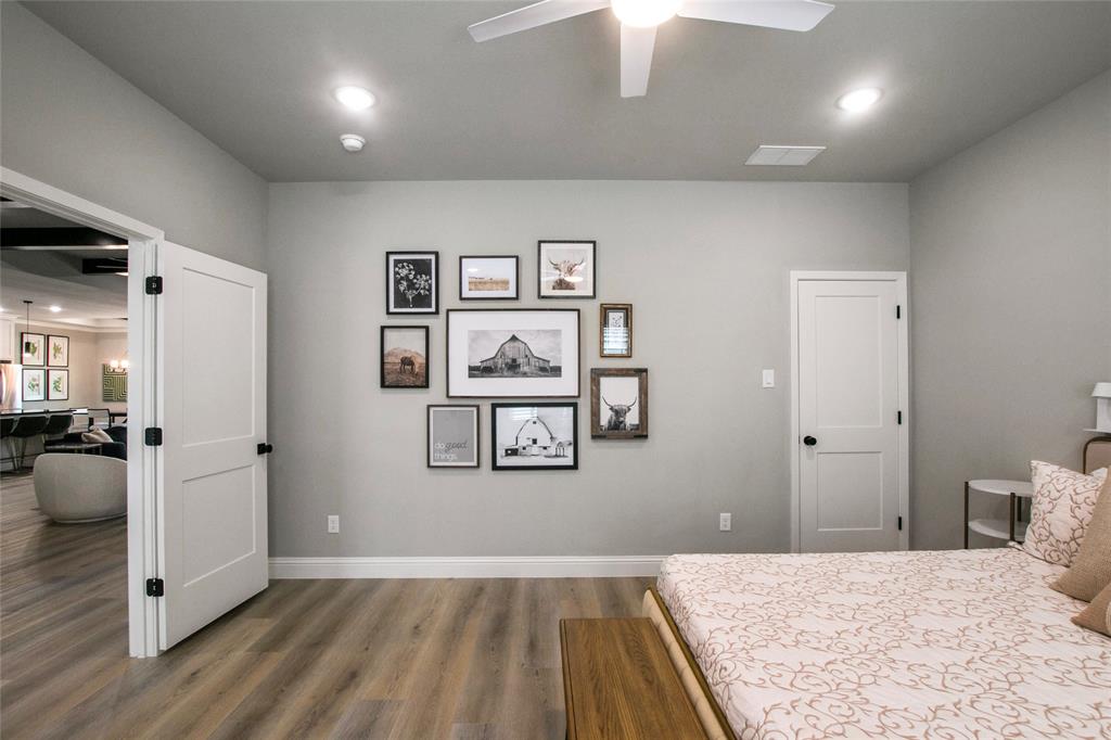 80 Dublin Circle Gordonville, TX 76245 - Photo 22 of 39 a bedroom with a large bed and a chandelier