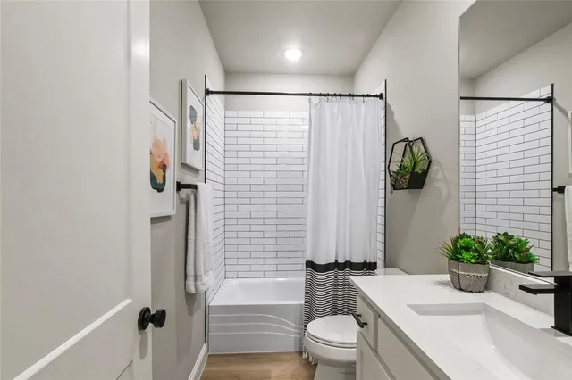 a bathroom with a shower a toilet and a sink