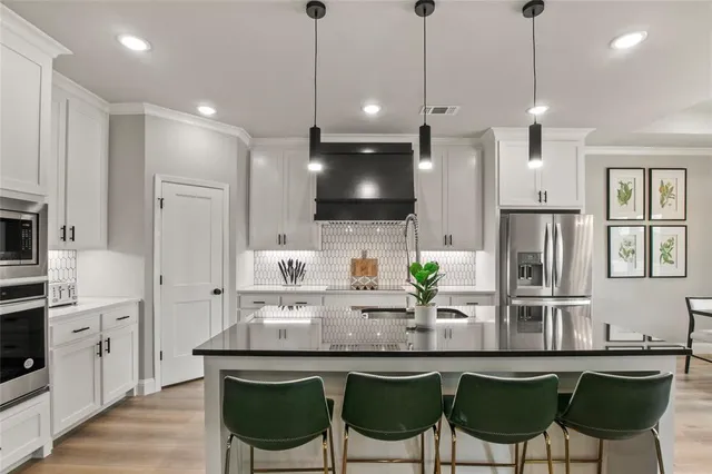 a kitchen with stainless steel appliances a dining table chairs sink and microwave