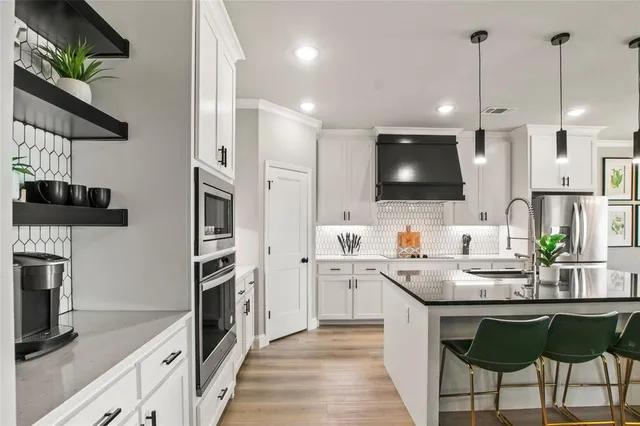 a kitchen with stainless steel appliances kitchen island granite countertop a sink and a stove