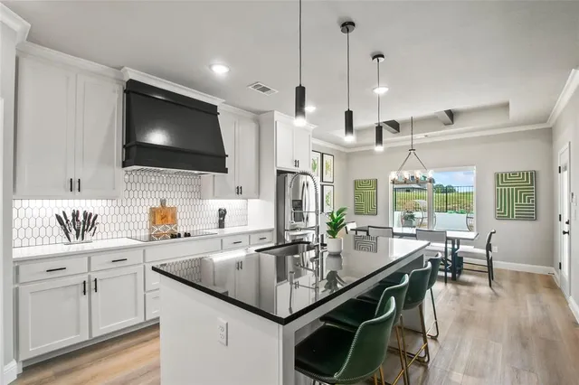 a kitchen with granite countertop a sink appliances and cabinets