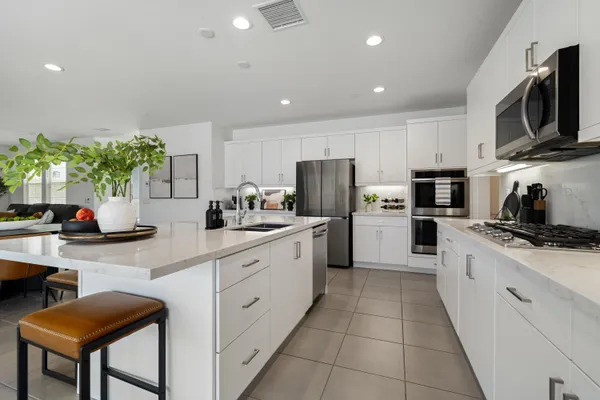 a kitchen with refrigerator and chairs