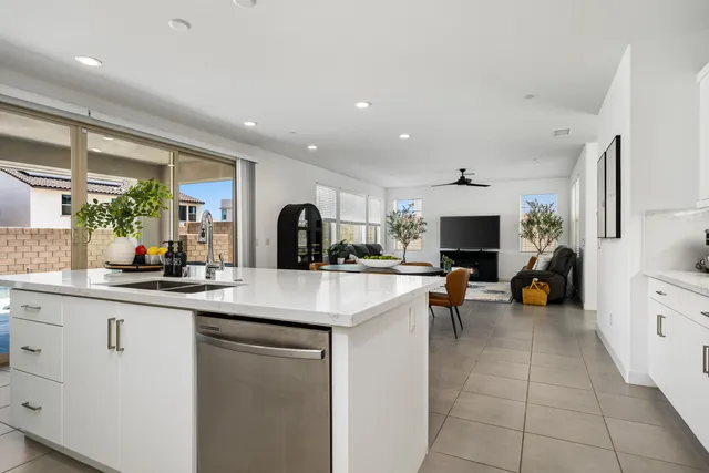 a kitchen with stainless steel appliances a dining table chairs microwave and sink