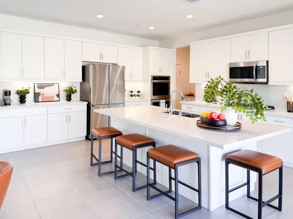 a kitchen with cabinets and chairs