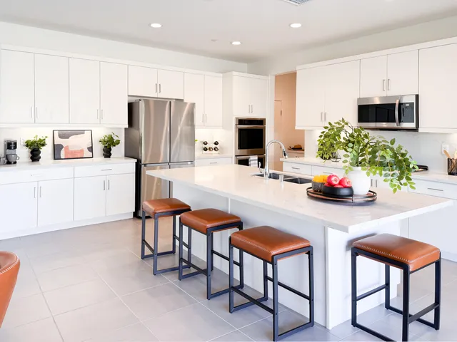 a kitchen with cabinets and chairs
