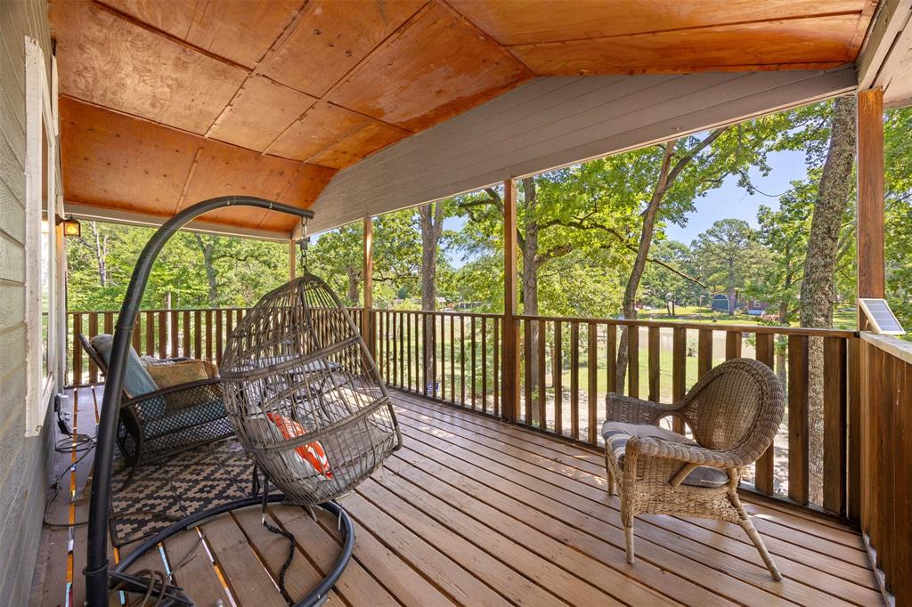 7110 Apache Circle Mabank, TX 75156 - Photo 27 of 39 Expansive covered porch featuring wood-finish flooring, a wood-paneled ceiling, and a wooden railing