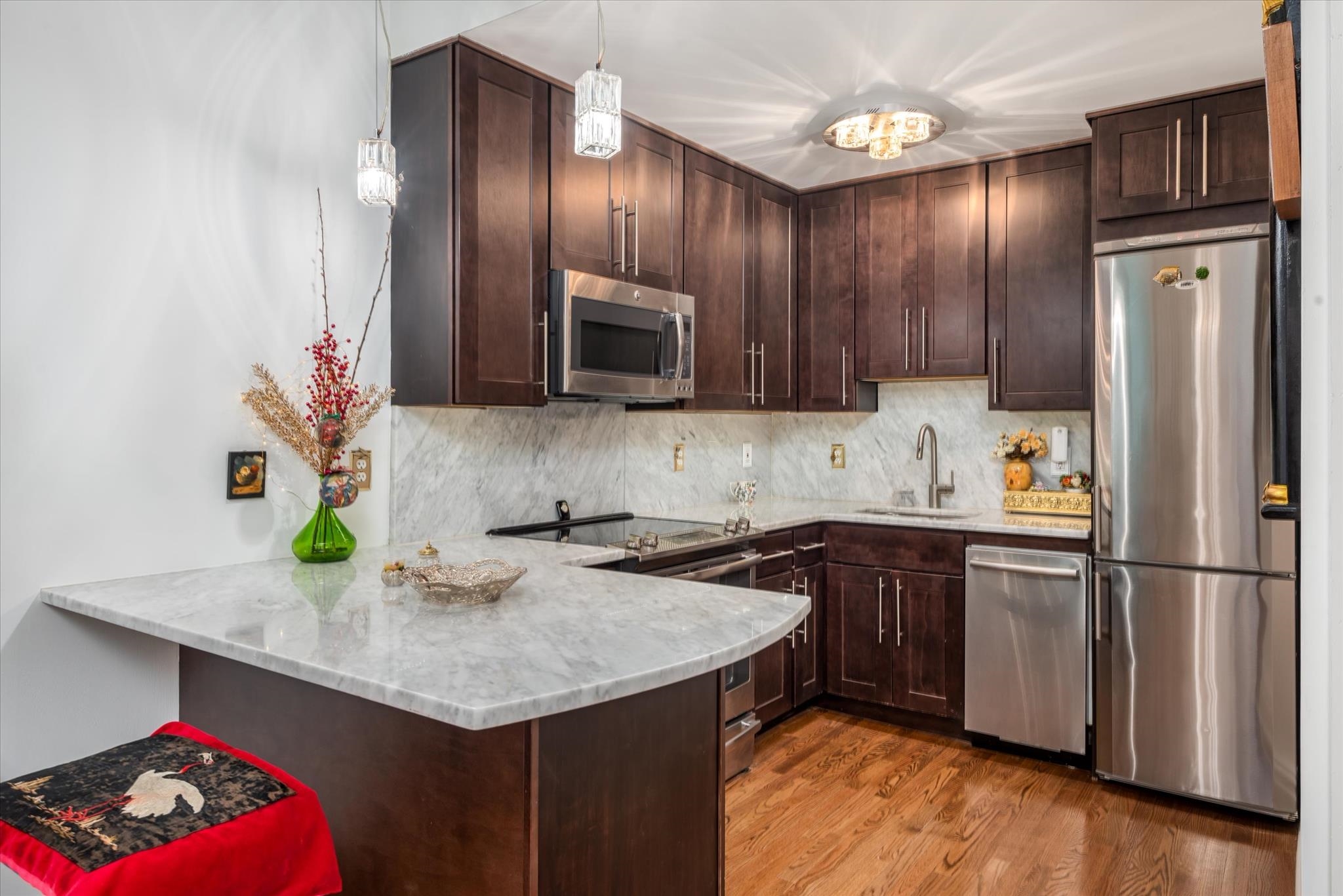 41-43 1st Street, Unit 1G Hoboken, NJ 07030 - Photo 9 of 26 a kitchen with granite countertop stainless steel appliances and wooden cabinets