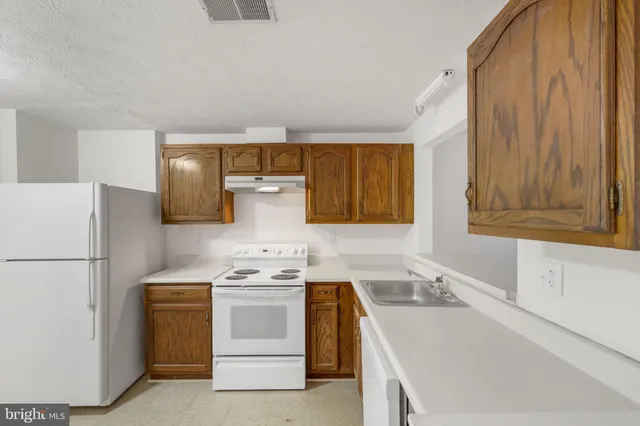a kitchen with stainless steel appliances a refrigerator sink and stove