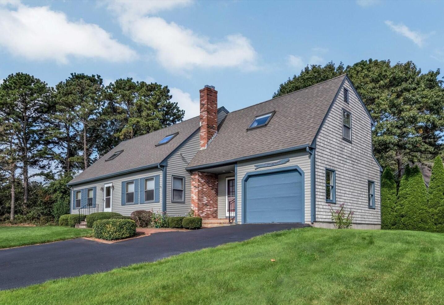 4 Surf Drive Mashpee, MA 02649 - Photo 1 of 22 a front view of a house with a garden and yard