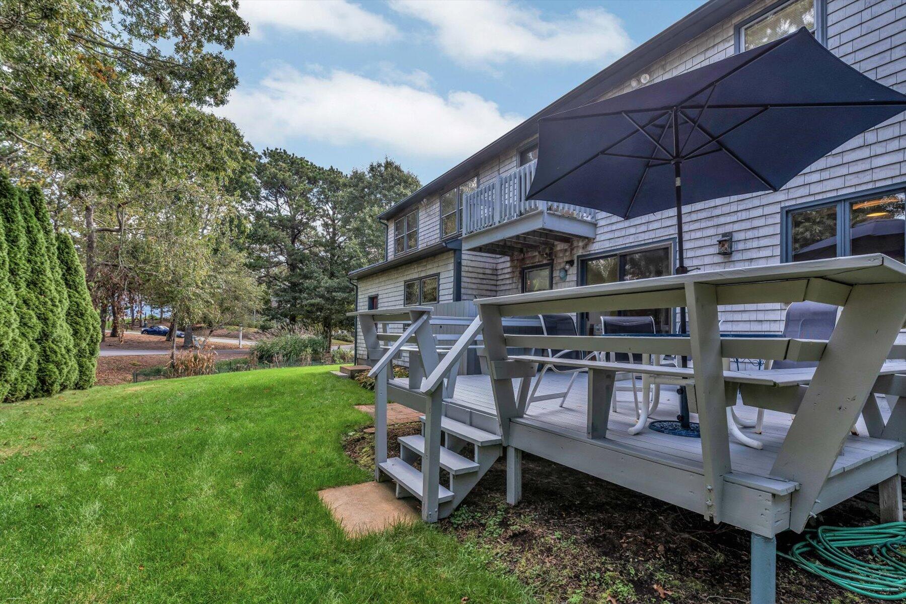 4 Surf Drive Mashpee, MA 02649 - Photo 15 of 22 an outdoor space with plants and umbrella