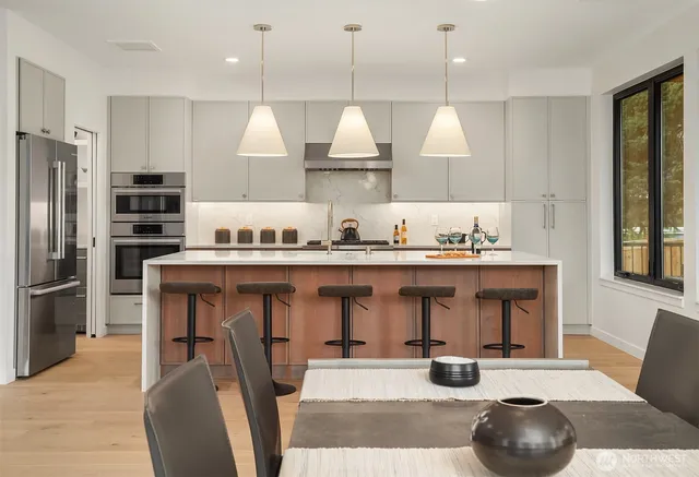 a kitchen with stainless steel appliances granite countertop a sink a stove and a refrigerator