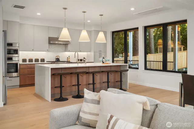 a large kitchen with stainless steel appliances kitchen island granite countertop a stove a sink a dining table and chairs