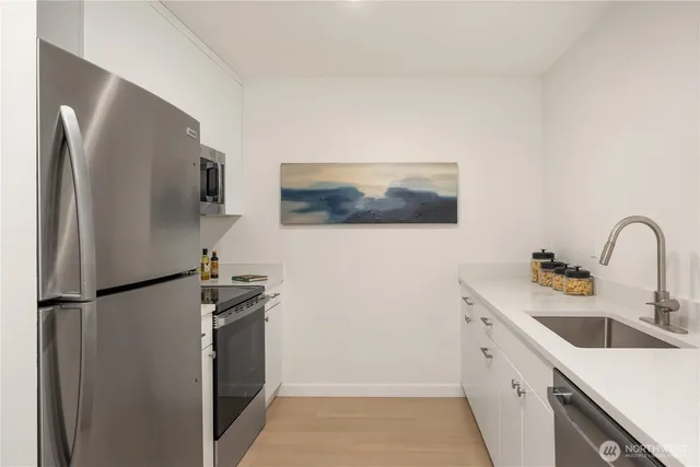 a kitchen with stainless steel appliances white cabinets white stove and a refrigerator with granite countertops