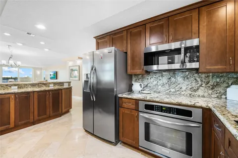 a kitchen with stainless steel appliances granite countertop a stove a refrigerator and a microwave