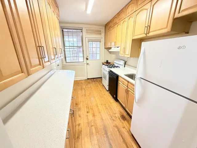a kitchen with a sink a refrigerator a stove and a window