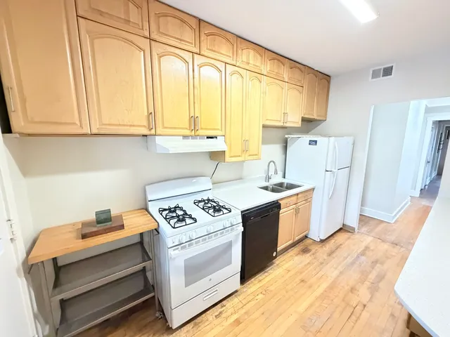 a kitchen with stainless steel appliances granite countertop a stove and a white cabinets