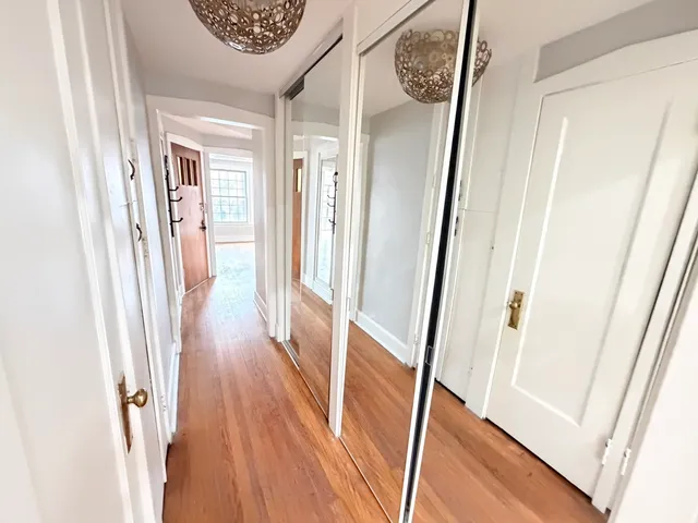 a view of a hallway with wooden floor and staircase