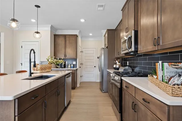 a large kitchen with a counter space a sink appliances and a living room view