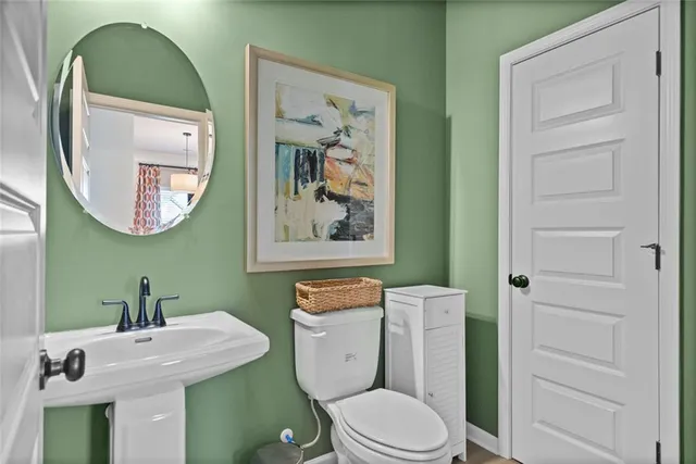 a bathroom with a toilet a sink and mirror