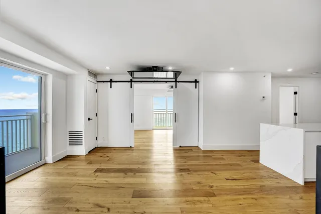 a view of empty room with wooden floor and window