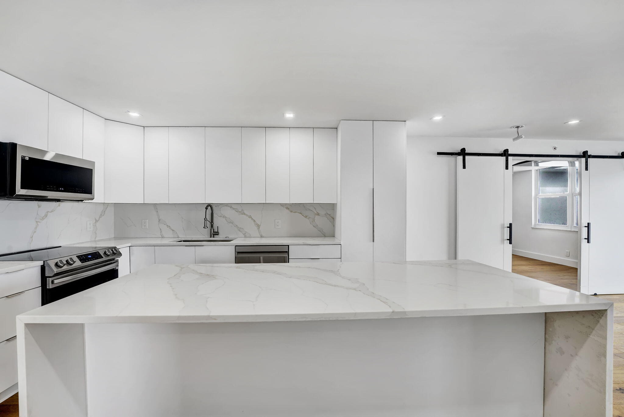 4511 South Ocean Boulevard, Unit 1008 Highland Beach, FL 33487 - Photo 3 of 32 a kitchen with stainless steel appliances a refrigerator a stove a microwave and white cabinets