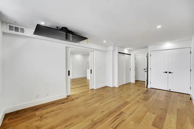 a view of empty room with wooden floor