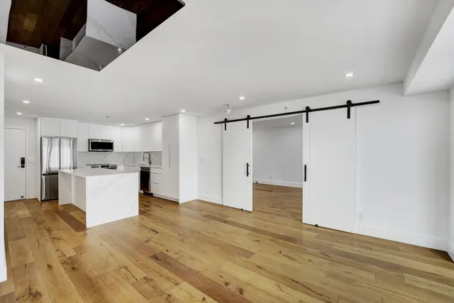 a view of a kitchen with a sink and a refrigerator