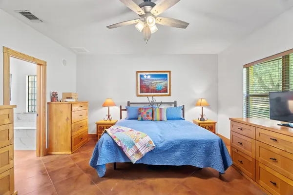 a bedroom with a bed and dresser with mirror