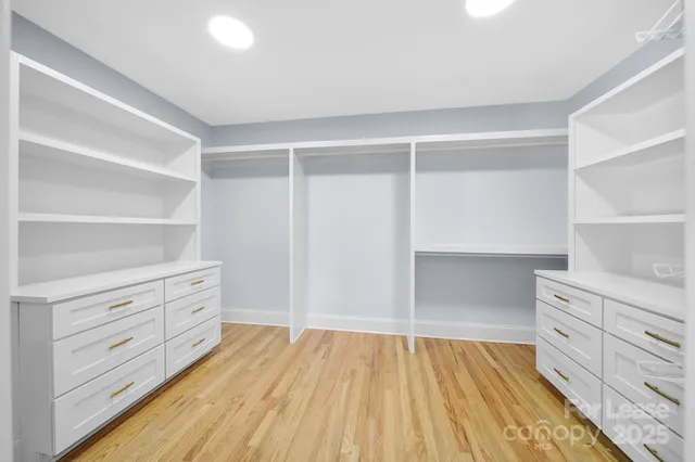 a view of an empty room with cabinets and wooden floor