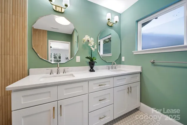 a bathroom with a double vanity sink and a mirror