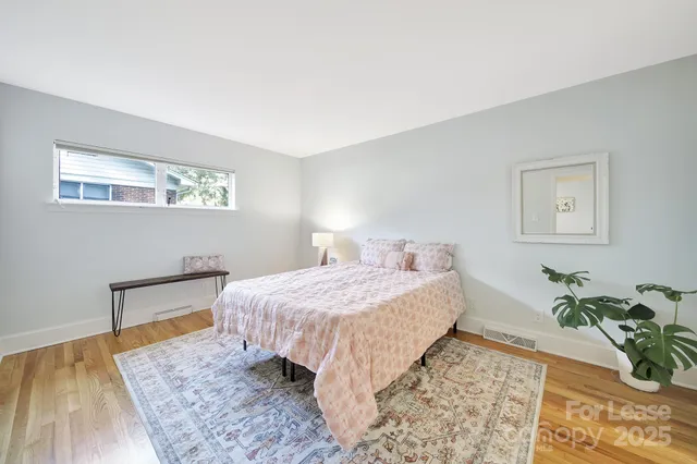 a bedroom with a bed and a painting on the wall