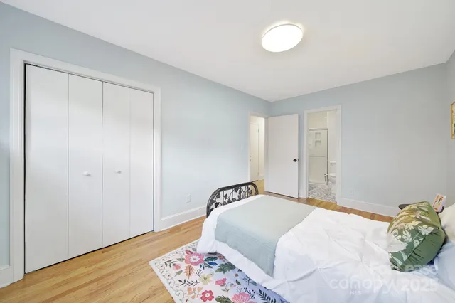 a bedroom with a bed and wooden floor