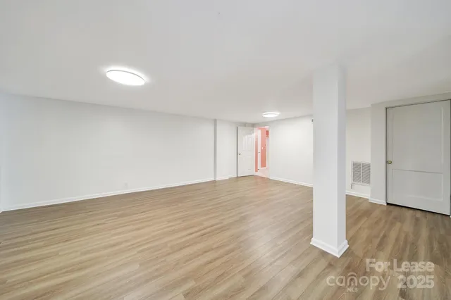 a view of empty room with wooden floor