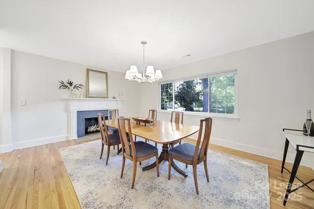 a view of a dining room with furniture a chandelier and wooden floor