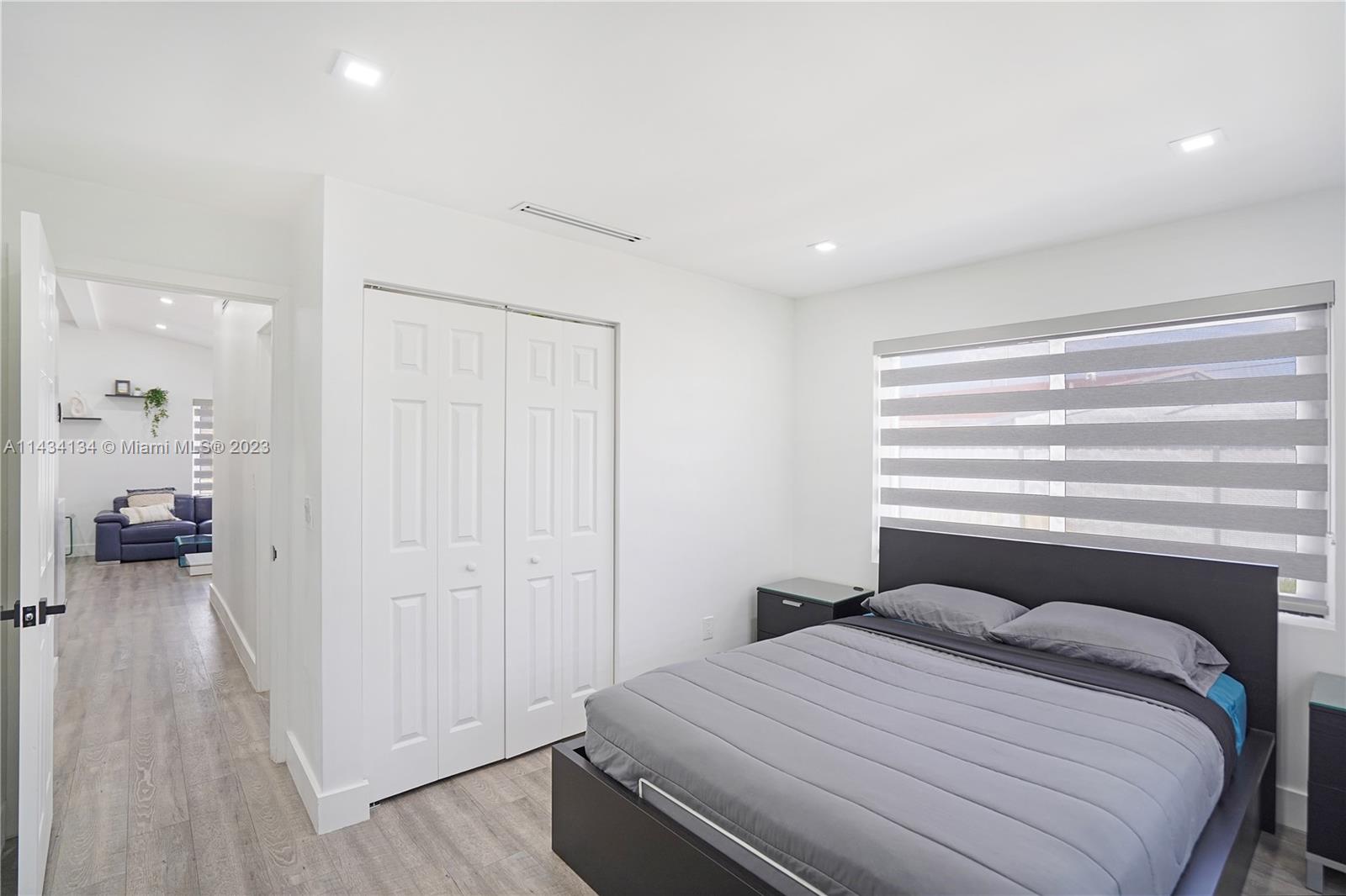 690 Southeast 3rd Place Hialeah, FL 33010 - Photo 6 of 31 a bedroom with a bed and a chandelier