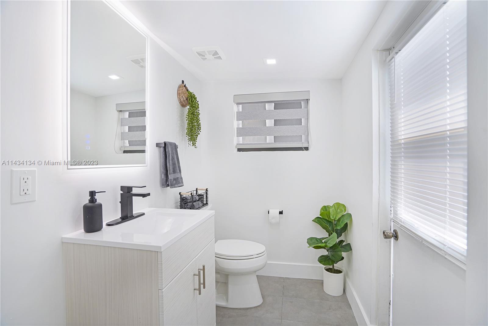 690 Southeast 3rd Place Hialeah, FL 33010 - Photo 7 of 31 a bathroom with a toilet sink and mirror