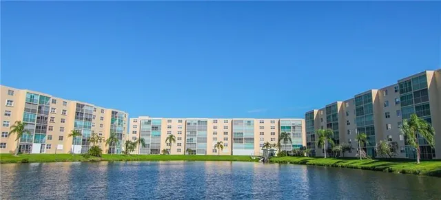 a view of building with lake and tall trees