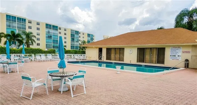 a front view of a house with swimming pool and porch with furniture