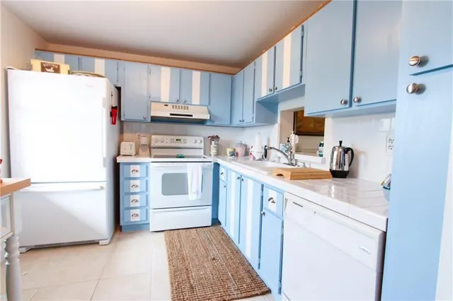 a kitchen with a refrigerator sink and cabinets